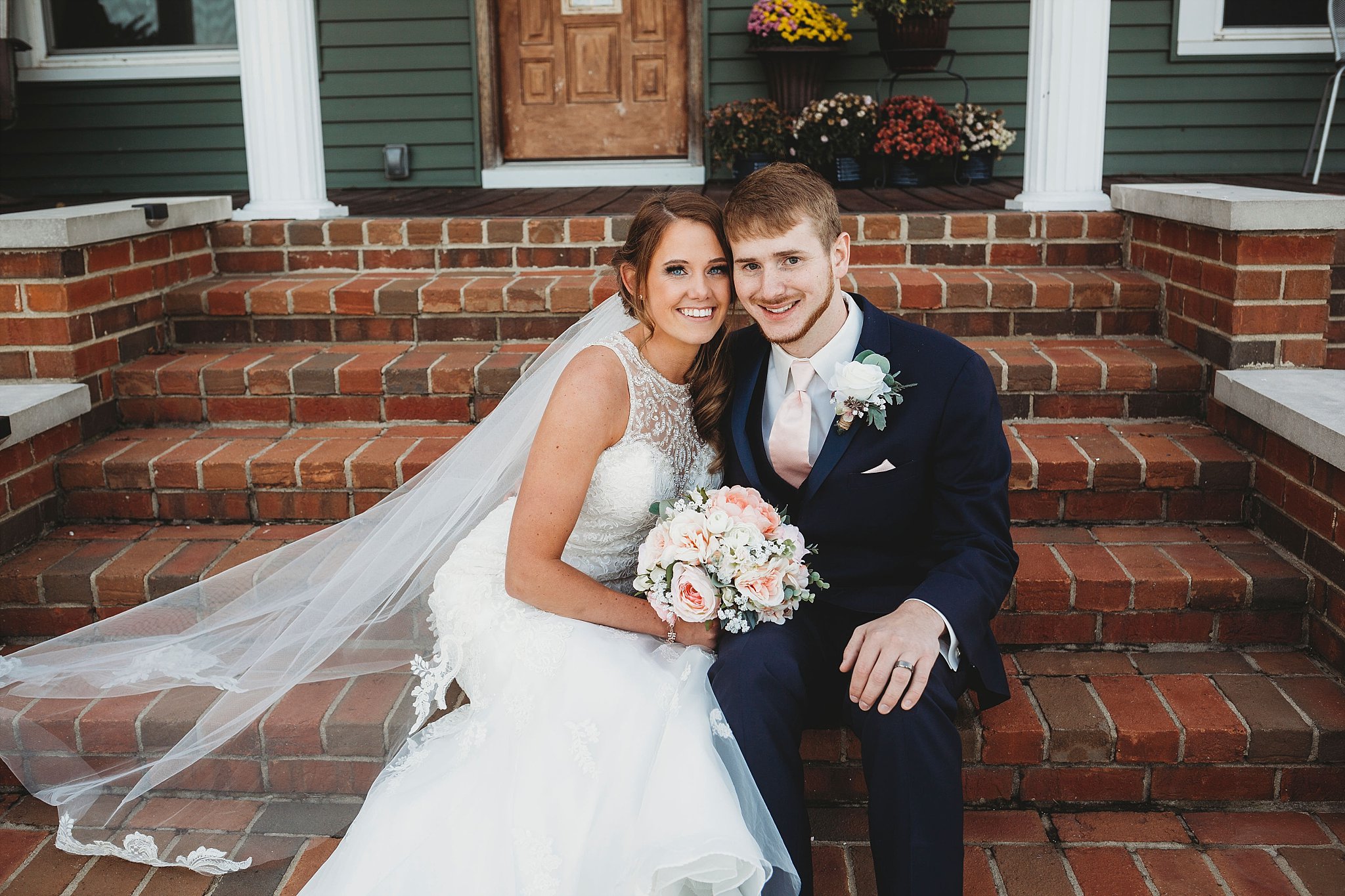 bride and groom sitting on the porch at  their meadow springs manor wedding in Francesville, Indiana