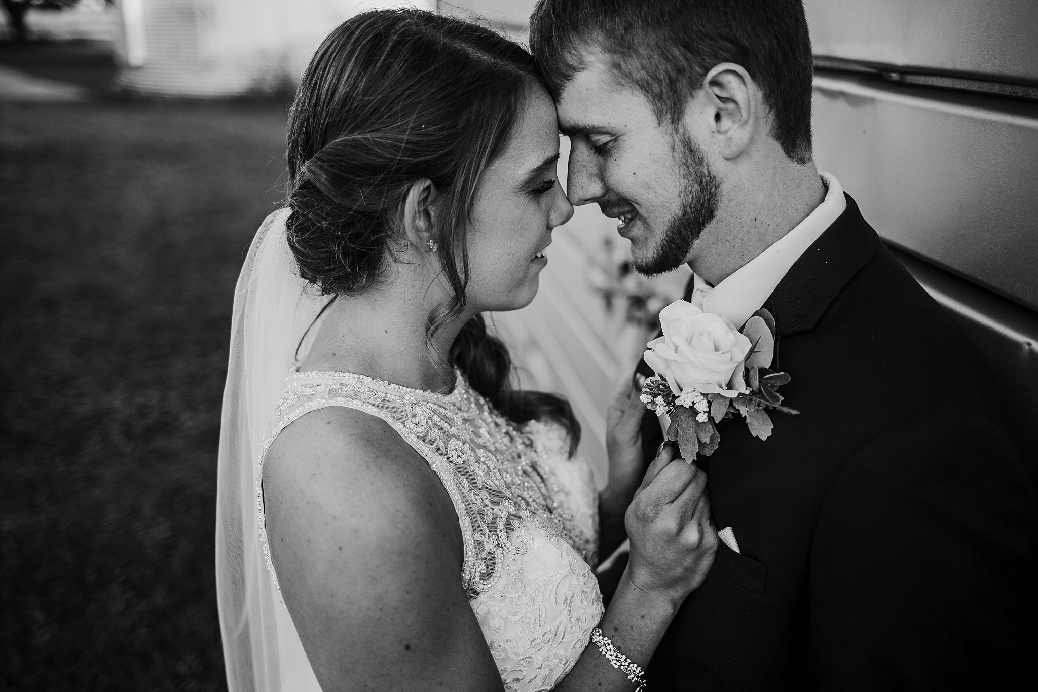 bride holding onto groom showing off her wedding ring at each other at their meadow springs manor wedding in Francesville, Indiana