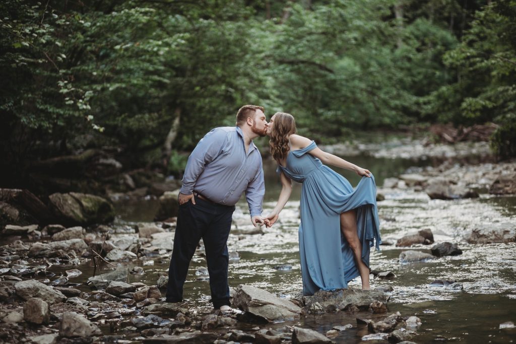 McCormick's Creek Engagement Session- Man and woman holding hands walking across the water at McCormick's Creek State Park in Indiana
