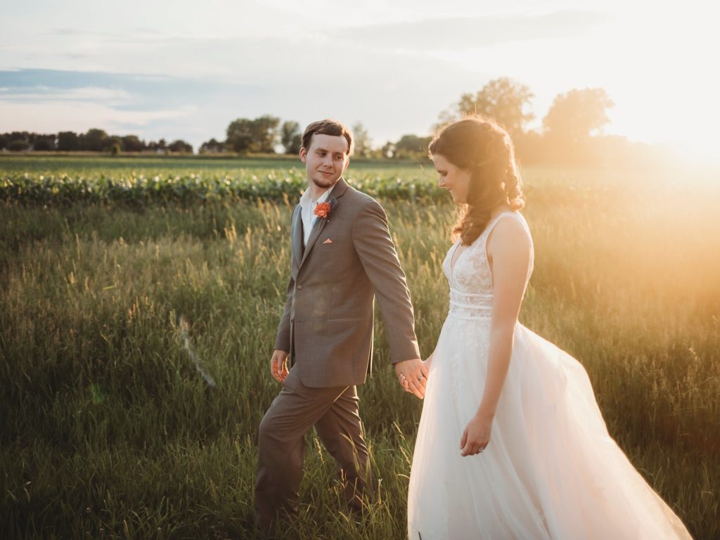 bride and groom walking together at sunset for their Monticello, Indiana wedding. 