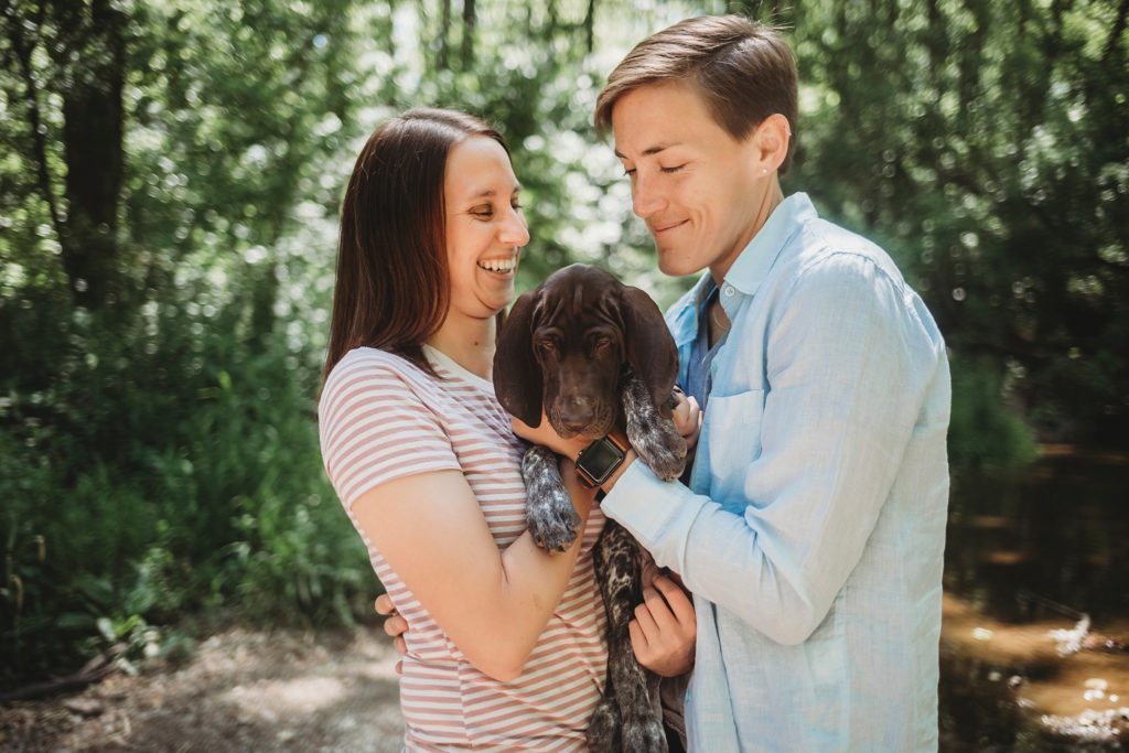 LGBTQ couple holds puppy while laughing at their Lafayette, Indiana couples session 