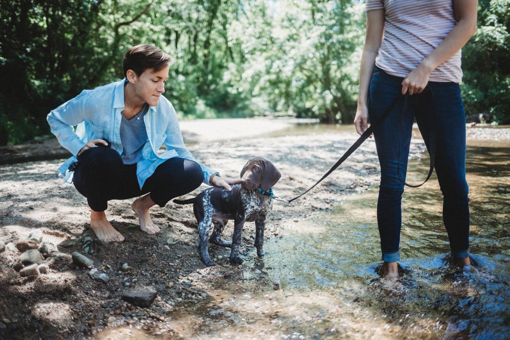 LGBTQ couple holds puppy on a leash while at their Lafayette, Indiana couples session 