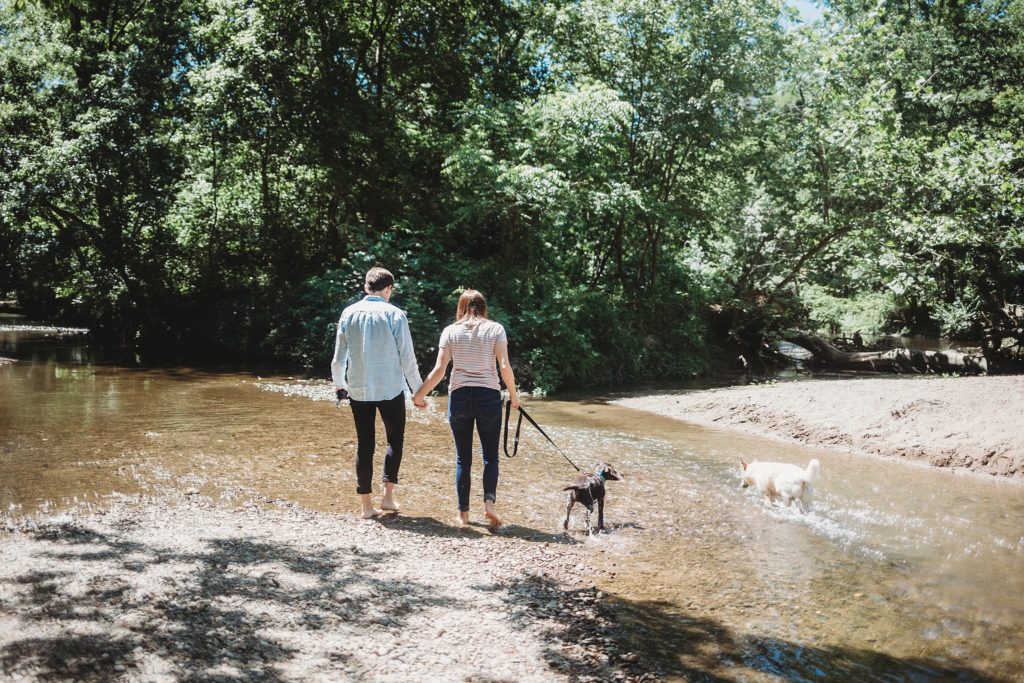 LGBTQ couple walking their dogs in the water at their Lafayette, Indiana couples session 