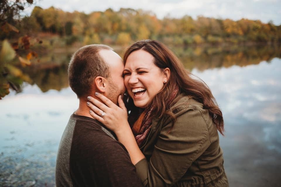 Posing Ideas From an Indianapolis Photographer- Man whispering into woman's ear during engagement session in Indianapolis, Indiana.
