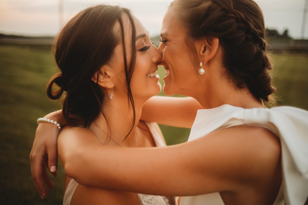 Our First Indiana LGBTQ+ Wedding- two women embrace for a kiss at The Gathering Barn in Bringhurst, Indiana