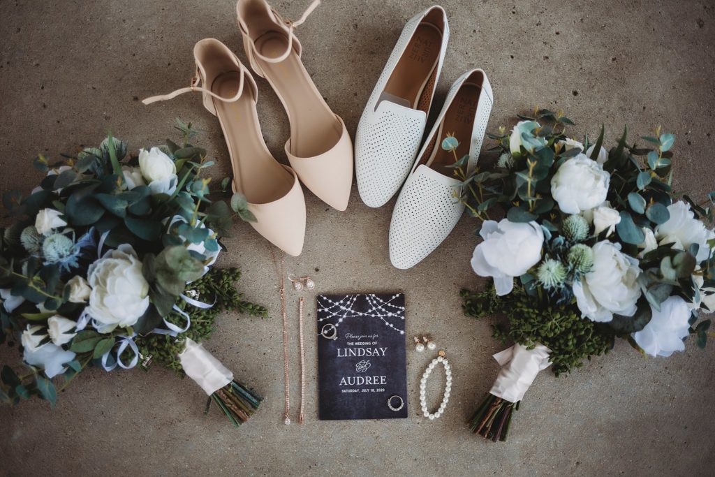 shoes, flowers, jewelry, and invitation laying together for lgbtq wedding ideas