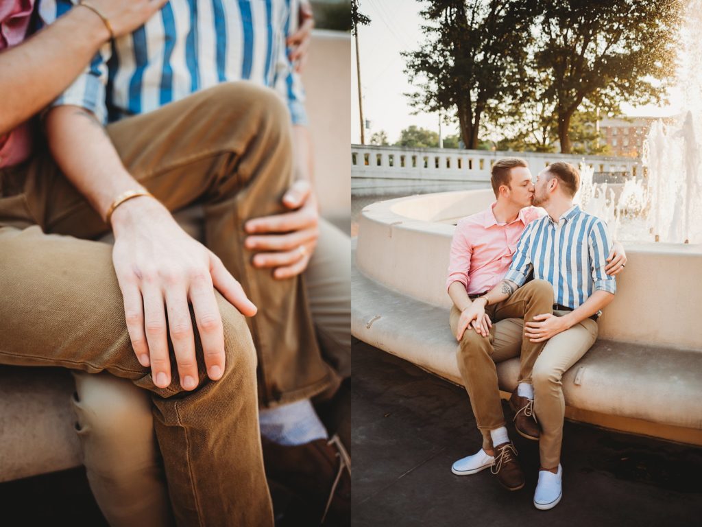 LGBTQ couple sitting near a water fountain while kissing during their Indiana LGBTQ engagement session. 