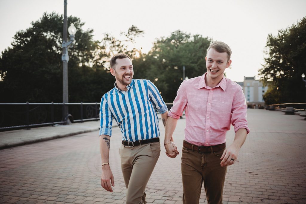 LGBTQ couple holding hands laughing during their Indiana LGBTQ engagement session. 