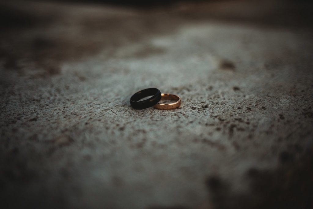 two mens engagement rings laying on top of one another