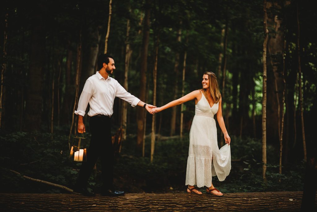 man and woman holding hands walking in the woods during their Indianapolis Indiana Anniversary Session