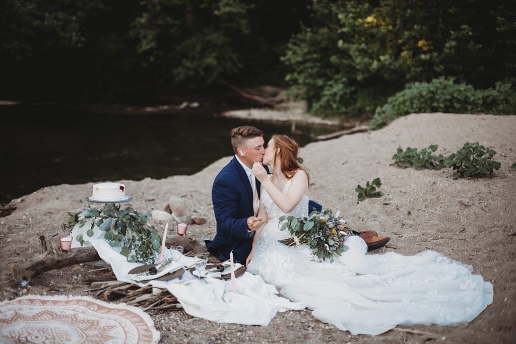 Indiana Elopement// Morgan + Kyle - Couple sit together in the sand kissing.  