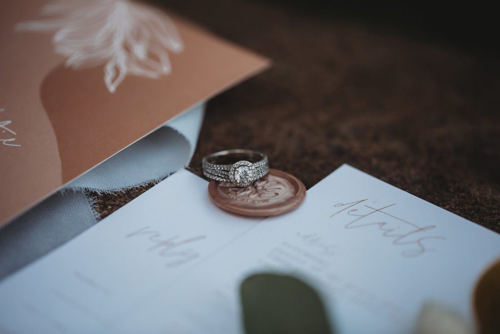 Include Your Family in Your Elopement- ring laying on a letter seal with stationary in colorado elopement