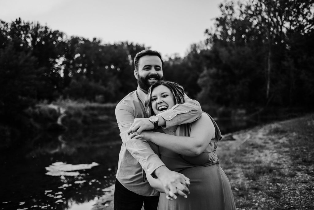 West Lafayette Indiana Couples Session// Evan + Abby - Man wraps woman in a bear hug from behind. Woman has a big smile on her face.