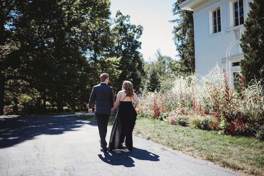 Newfields Engagement Session// Michelle + Adam - Couple walk hand in hand together away from the camera.