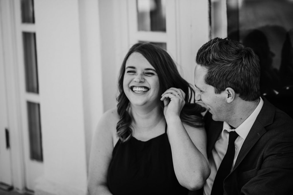 Newfields Engagement Session// Michelle + Adam - Couple sits together laughing at the Lilly House. 