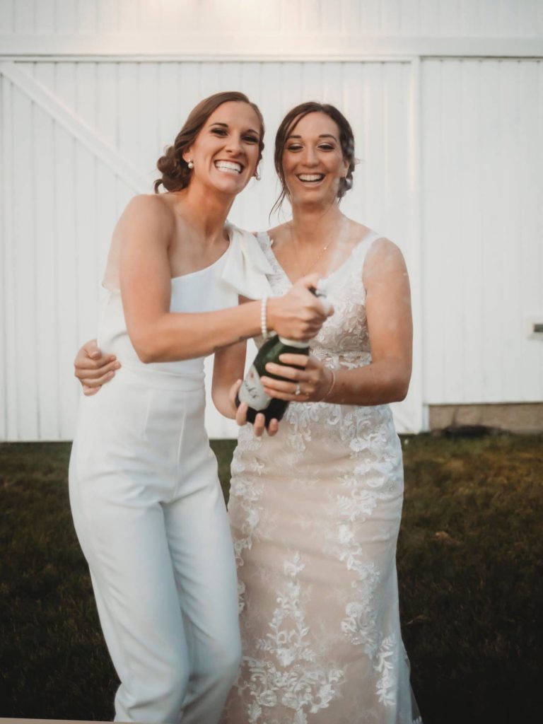 how to photograph popping champagne-two woman holding bottle of champagne while it pops 