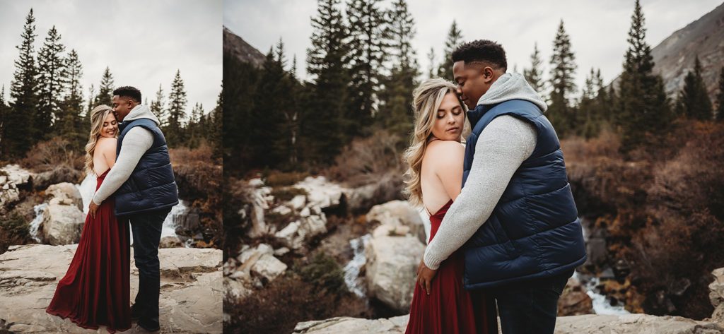 Man holding onto woman in front of a waterfall in colorado photos 