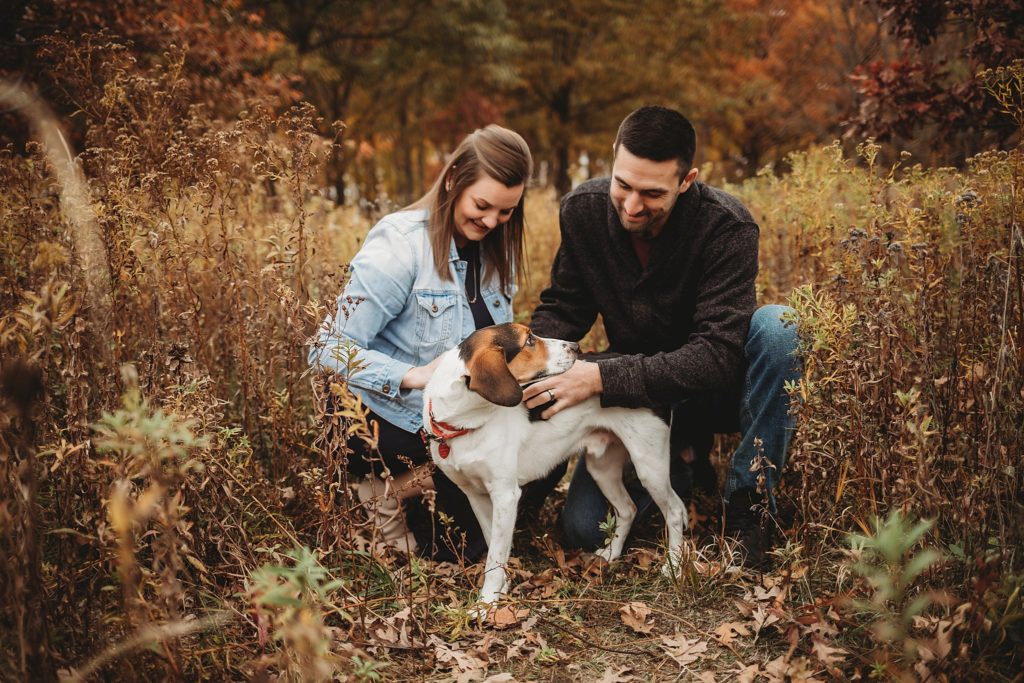 man and woman petting their dog in a park at their West Lafayette Couples Session
