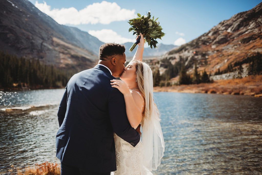 Bride and groom kissing during first look at Blue Lakes in Breckenridge Colorado Elopement 