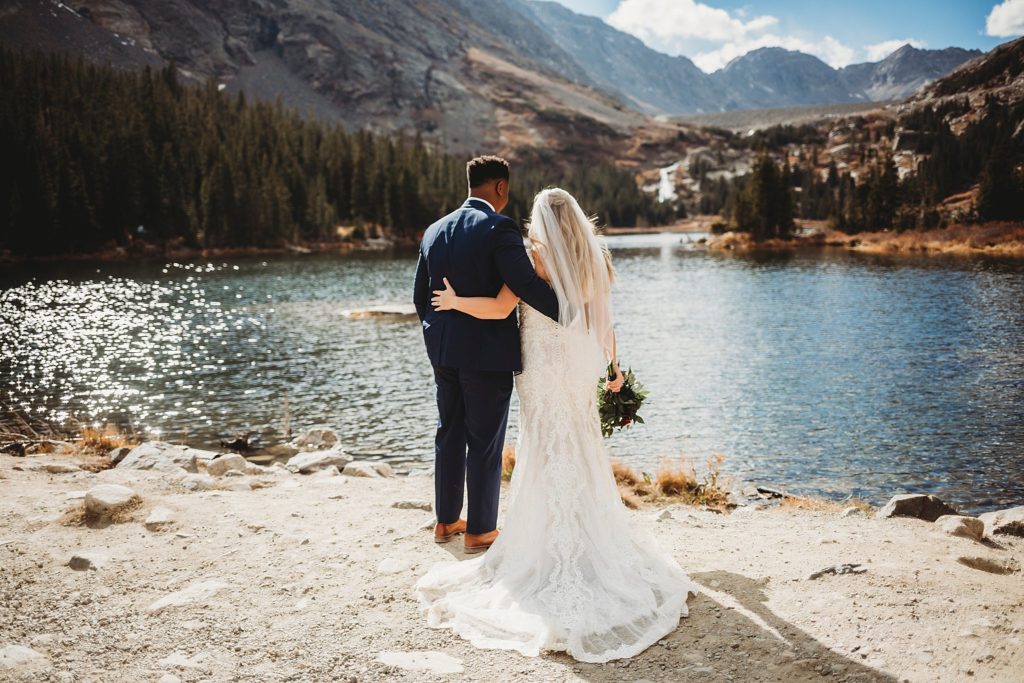Bride and groom looking off over the water at Blue Lakes in Breckenridge Colorado Elopement 