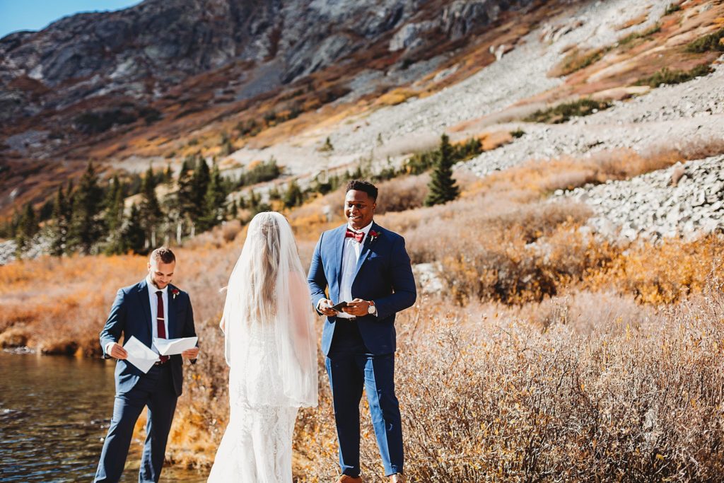 bride and groom reading vows to each other at Blue Lakes in Breckenridge Colorado Elopement 