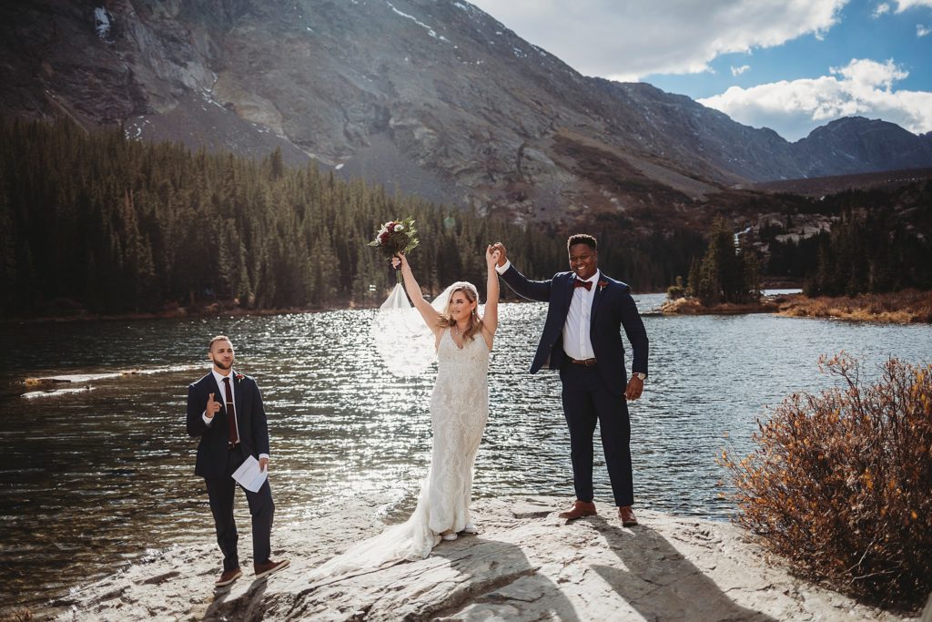 Breckenridge Colorado Elopement// Husband + Wife throw arms up after just getting married at Blue Lakes in Breckenridge, Colorado