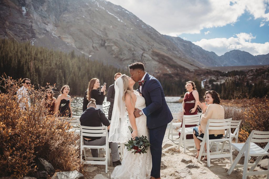 bride and groom kissing in front of their guests at Blue Lakes in Breckenridge Colorado Elopement 