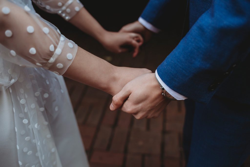 close up picture of bride and grooms hands