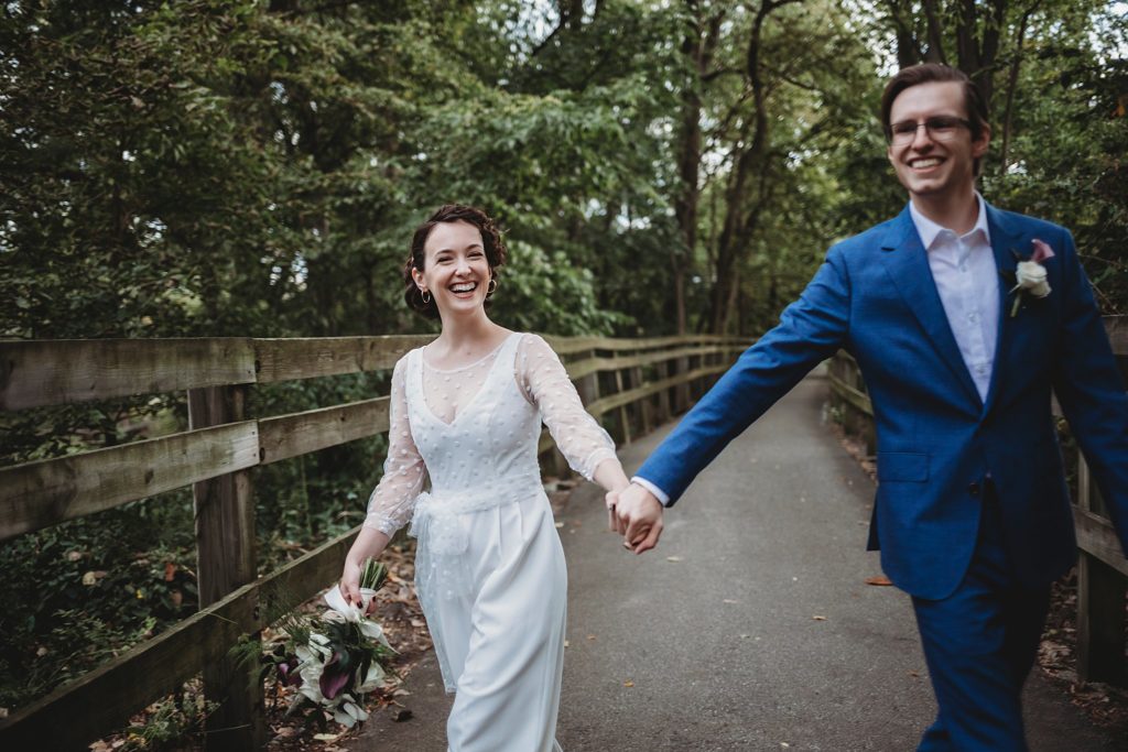 bride and groom hold hands walking towards camera