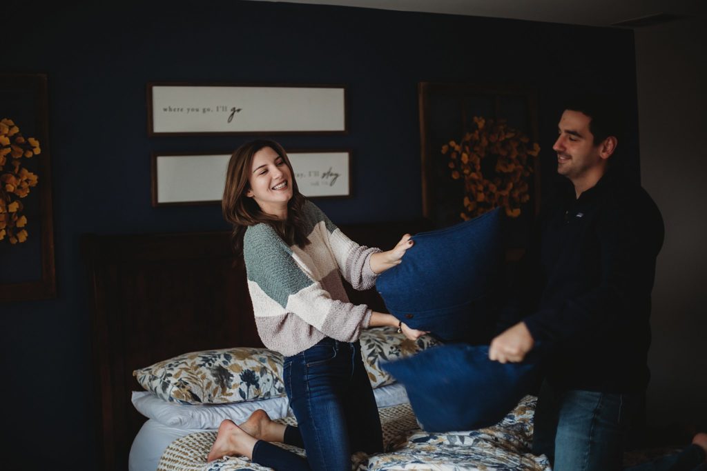 Woman hitting man with pillow at their Crown Point Indiana Engagement Session