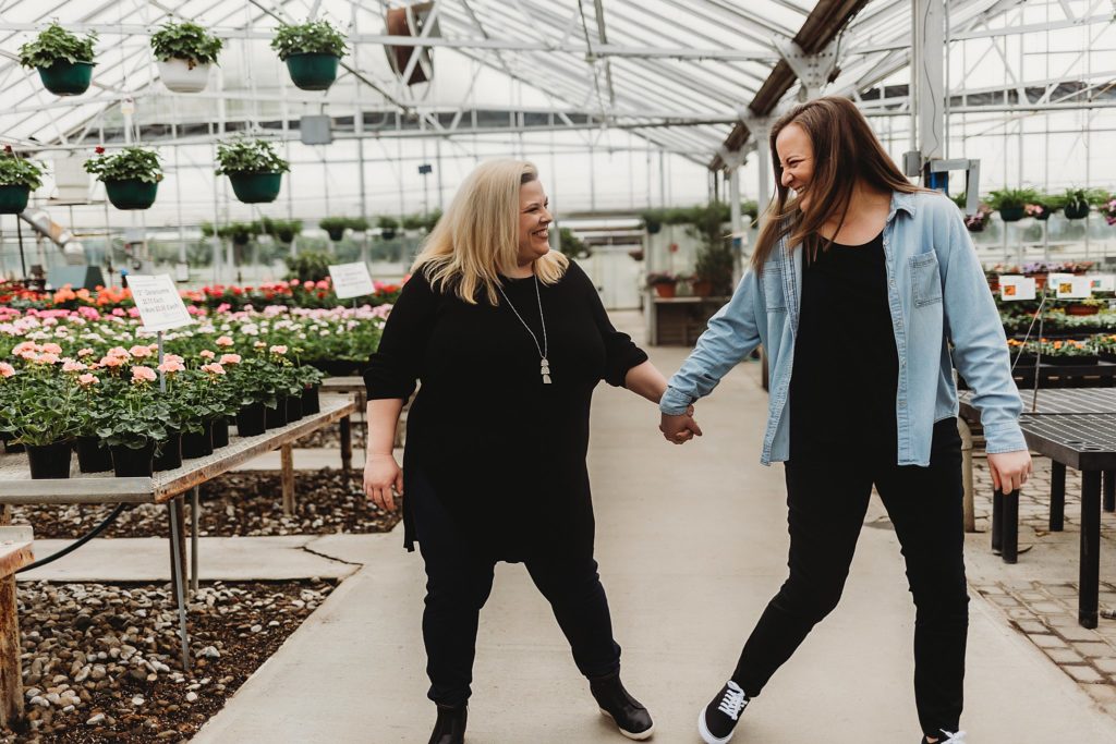 couple holding hands and walking through the Indiana Greenhouse