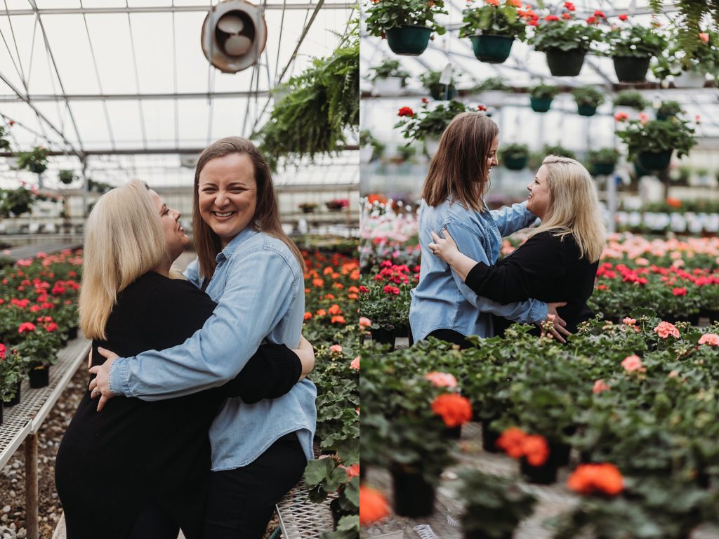 couple dancing down an isle of the green house while smiling and having a good time