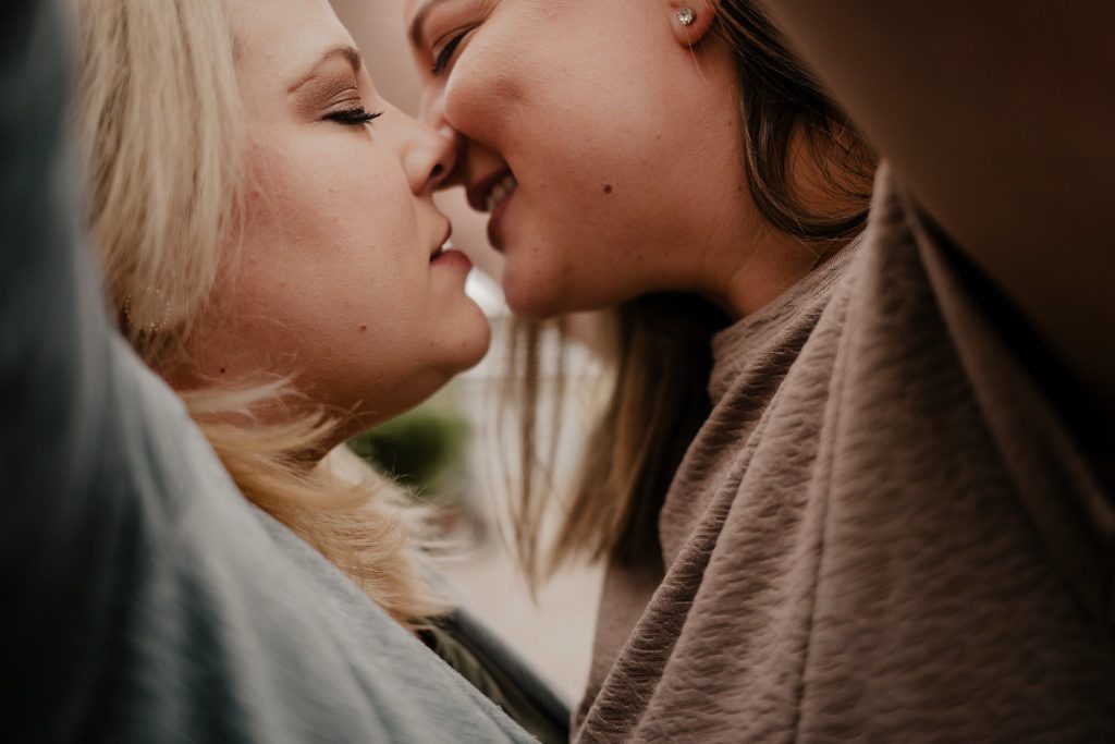 close up of couple preparing to kiss each other while camera angle is below arms which frame the photo