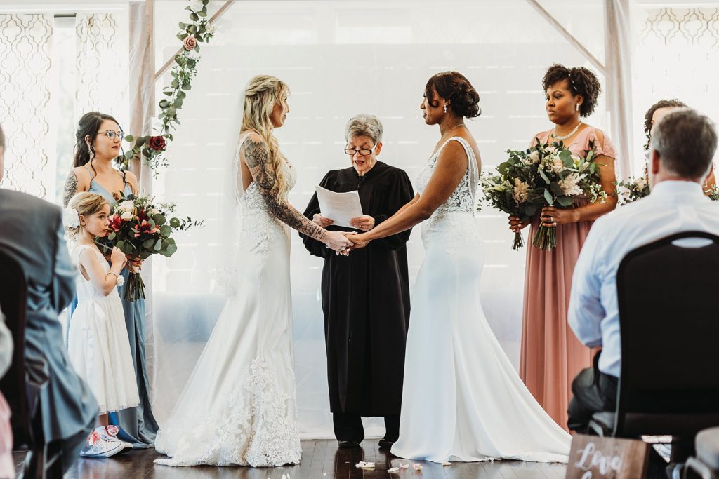 lgbtq weddings - LGBTQ couple holding hands and exchanging vows at their indiana wedding