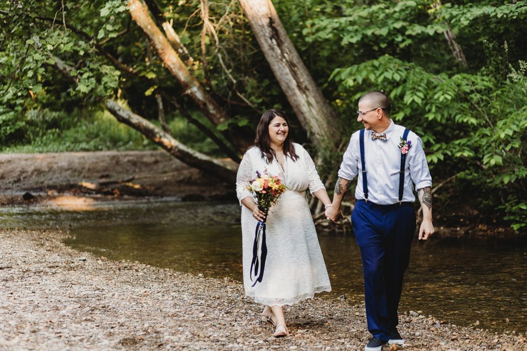 Indianapolis Indiana Elopement- man and woman walking hand in hand along a river in their Indianapolis, Indiana Elopement