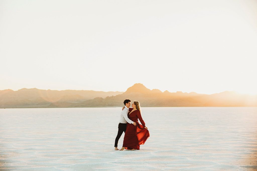 A couple hugs and dances on the Bonneville Salt Flats after eloping.