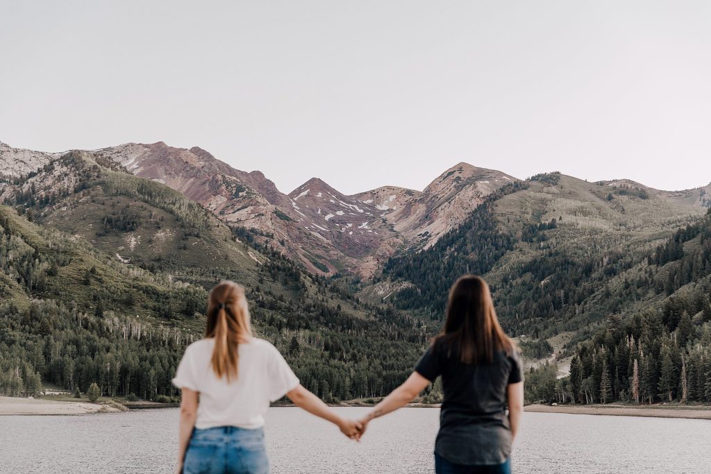Two women walking together with mountains in the background at their american fork canyon anniversary session