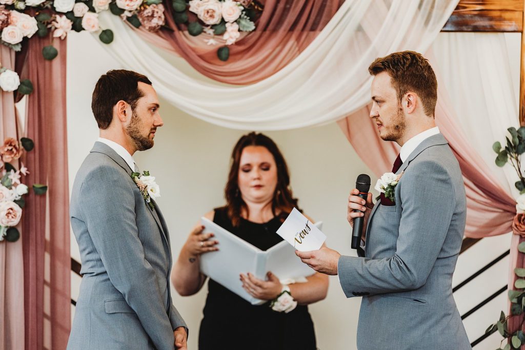 man and man reading vows to one another at their New Journey Farms Wedding in Lafayette, Indiana