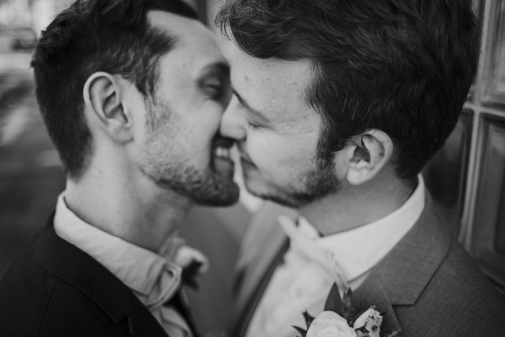 Two men kissing at an Indianapolis Wedding Venue called the ivory foundry
