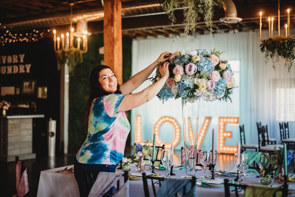 Amelia Marie Florals putting together a floral display in a vase at the Indianapolis Wedding Venue called The Ivory Foundry