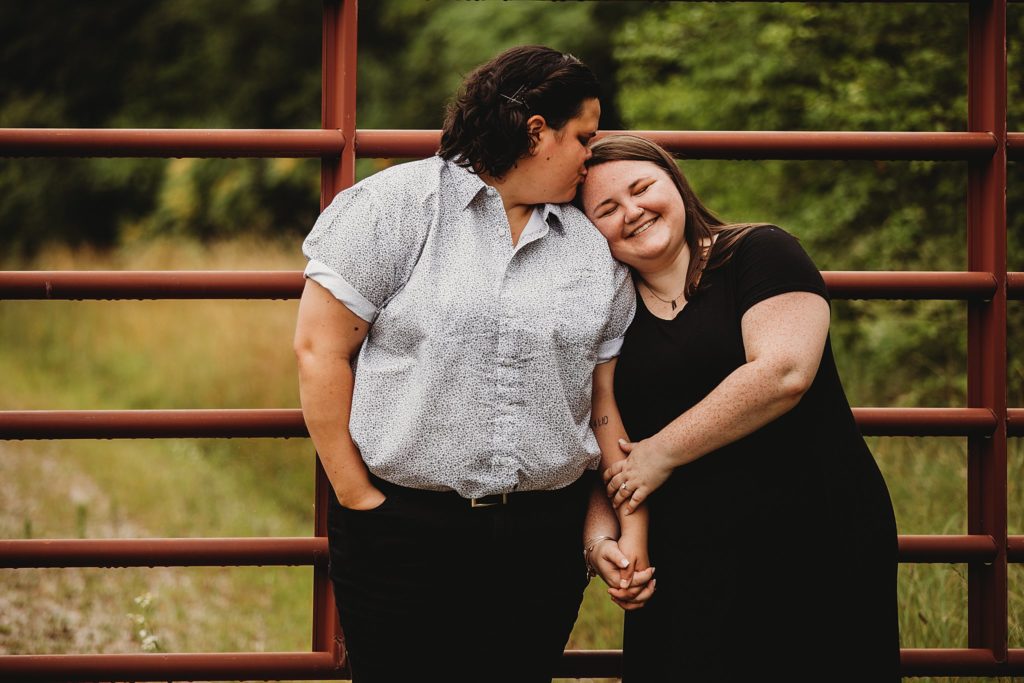 woman kissing womans forehead at a park at their Indianapolis LGBTQ Engagement Session