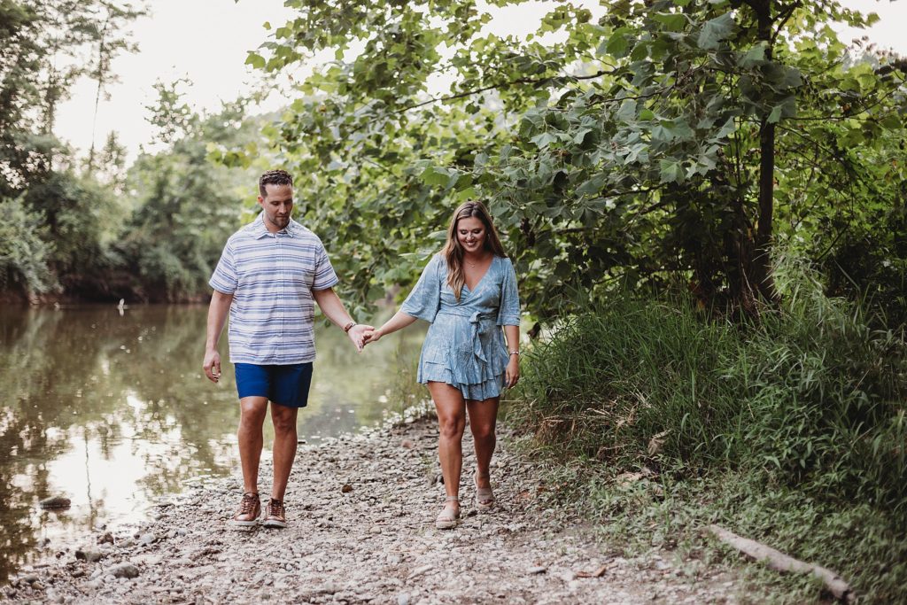 Lafayette Indiana Wedding Photographer captures man and woman walking hand in hand while smiling at each other 