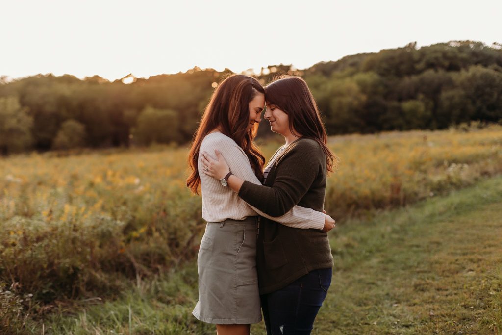 Two women lean their heads together and smile during their Chicago LGBTQ Couples Session