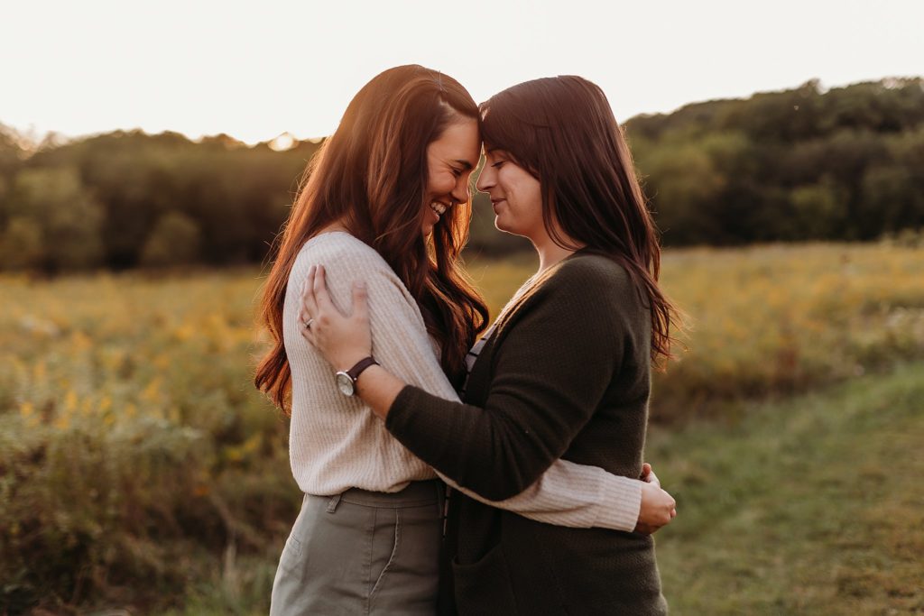 Two women lean their heads together and smile during their Chicago LGBTQ Couples Session