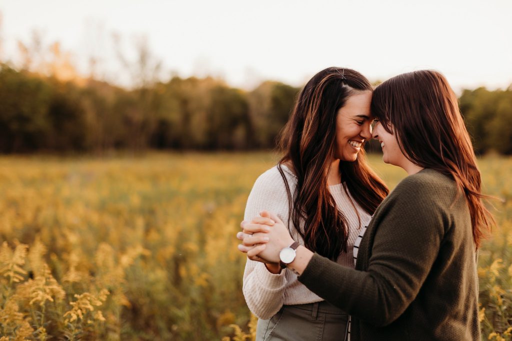 two women dancing in a field of yellow flowers during their Chicago LGBTQ Couples Session