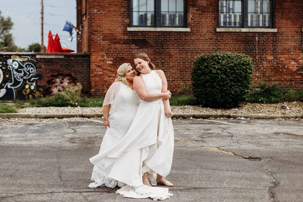 Indiana City Brewing Company Wedding - Two brides dancing and smiling in front of Indiana City Brewing Company