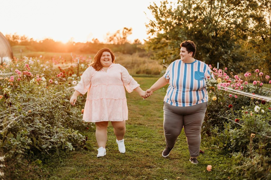 LGBTQ Wedding Tips - to woman holding hands walking through a flower field in lafayette, Indiana