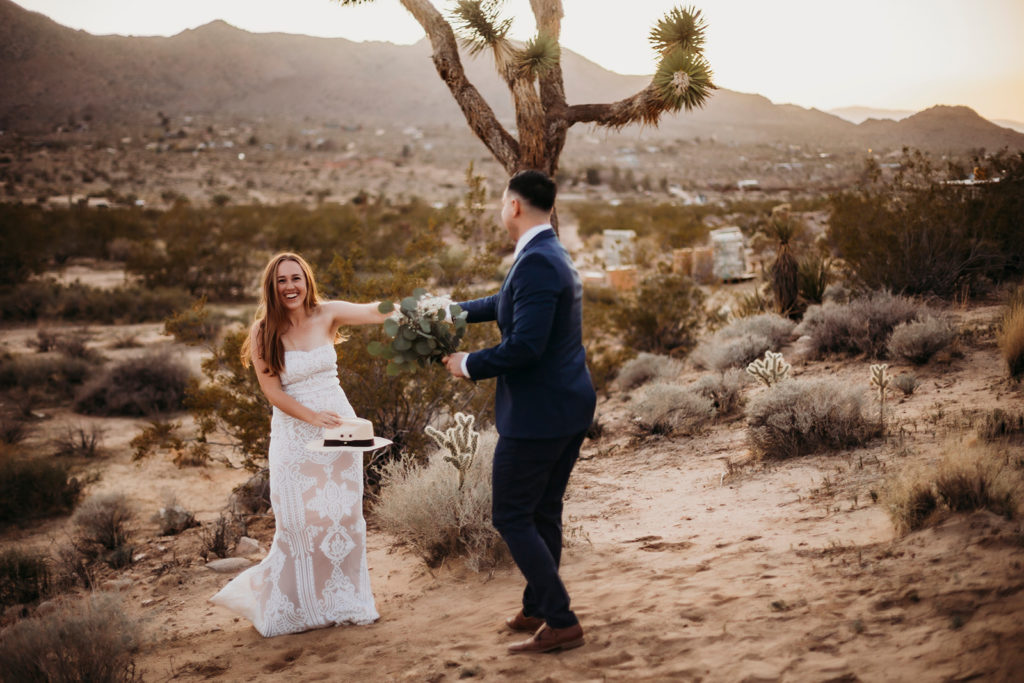 couple is dancing in front of the joshua trees in joshua tree national park at their california elopement