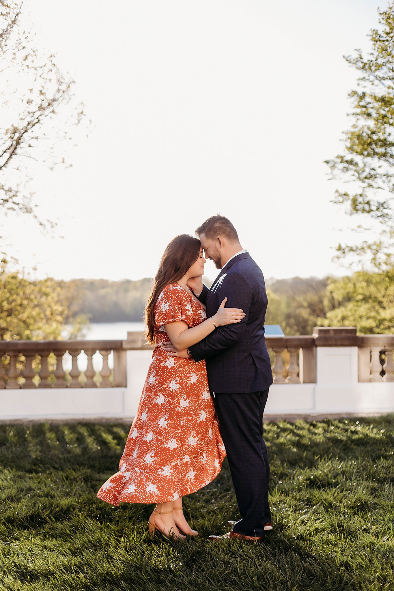 man and woman leaning their heads together and smiling at one another during their newfields engagement photos in indianapolis indiana