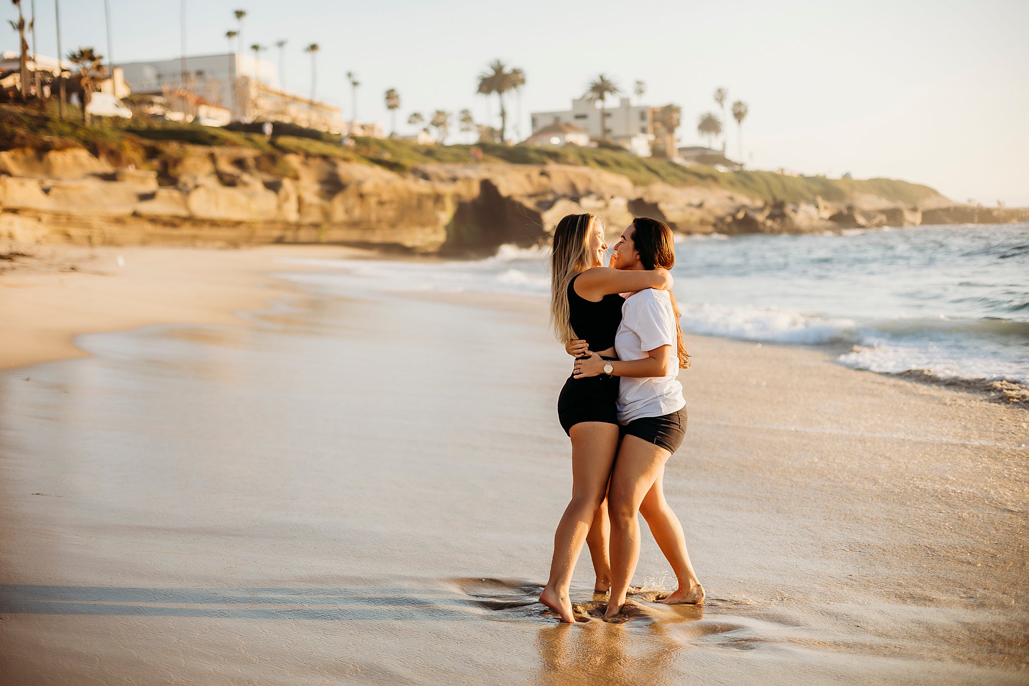 lgbtq couple kissing each other while the waves crash behind them at their La Jolla California Couples Session